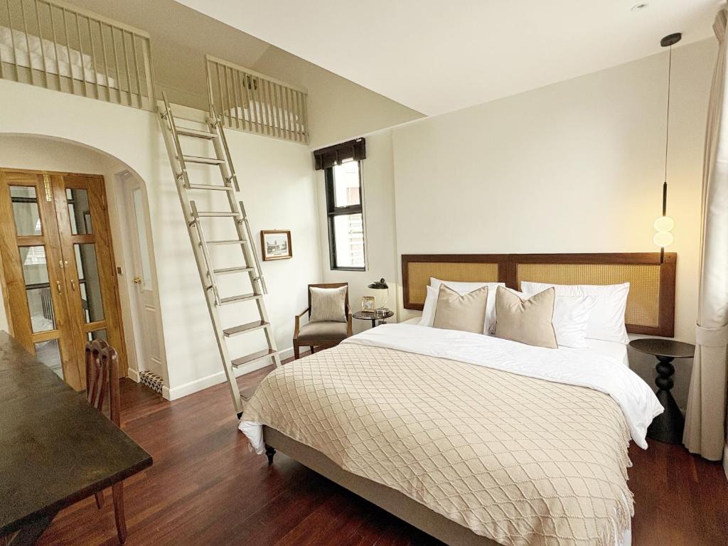 a bedroom with a large bed and a ladder at Pennkiat House in Bangkok