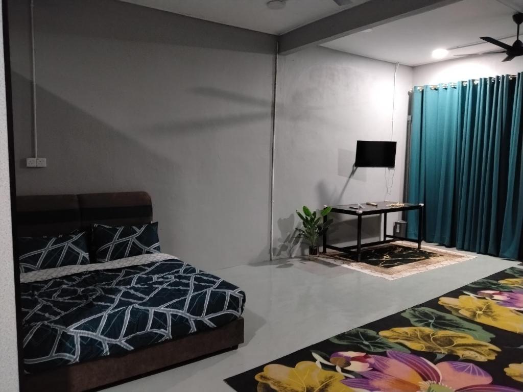 a bedroom with a bed and a table and a window at Roomstay Ust Omar in Tumpat