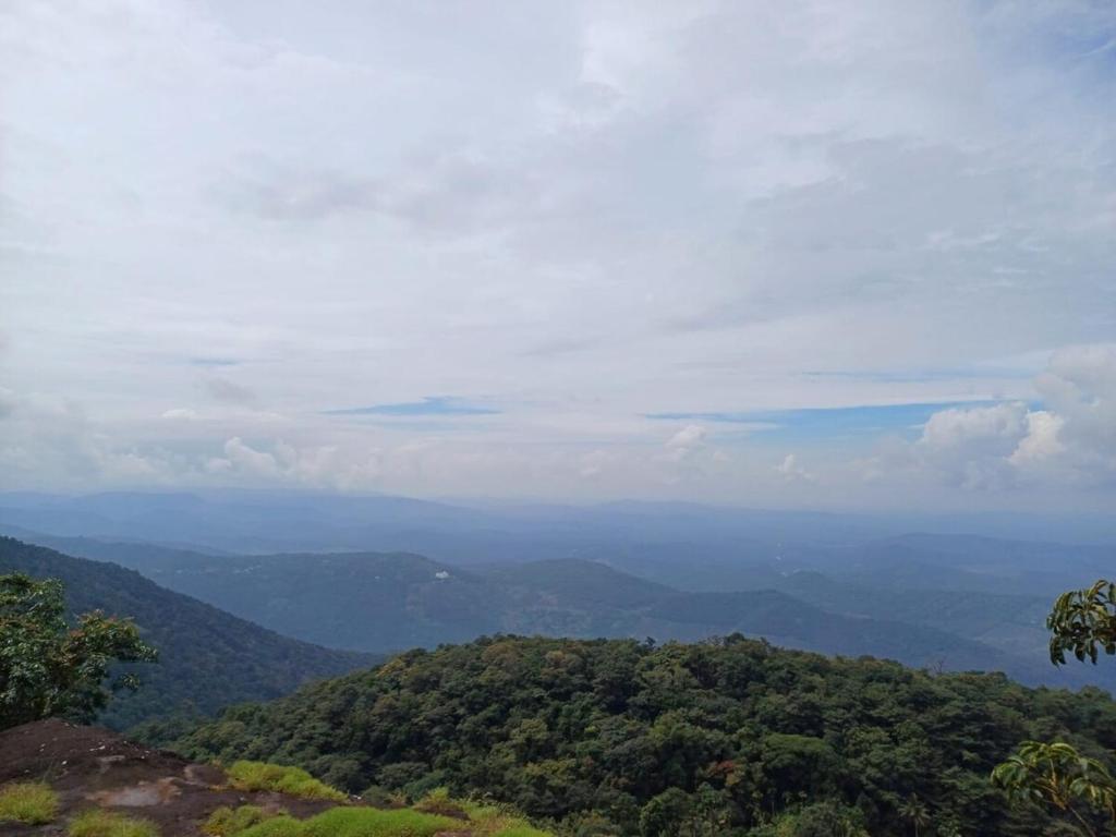 a view of a valley from a mountain with trees at Casa De Campo in Idukki