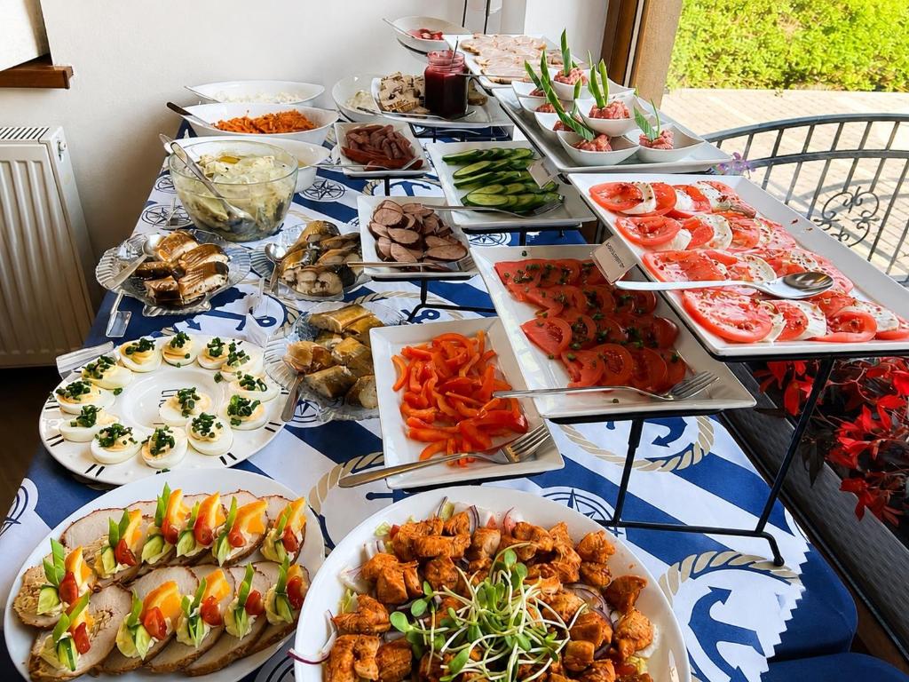a table with many plates of food on it at Willa Kapitańska i Willa Marynarska in Łeba