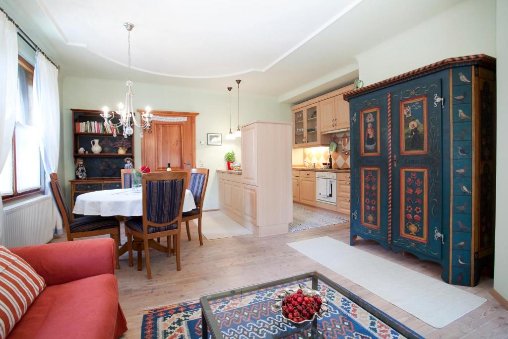 een woonkamer met een tafel en een blauwe kast bij Apartments im Garten - Haus Anna in Graz