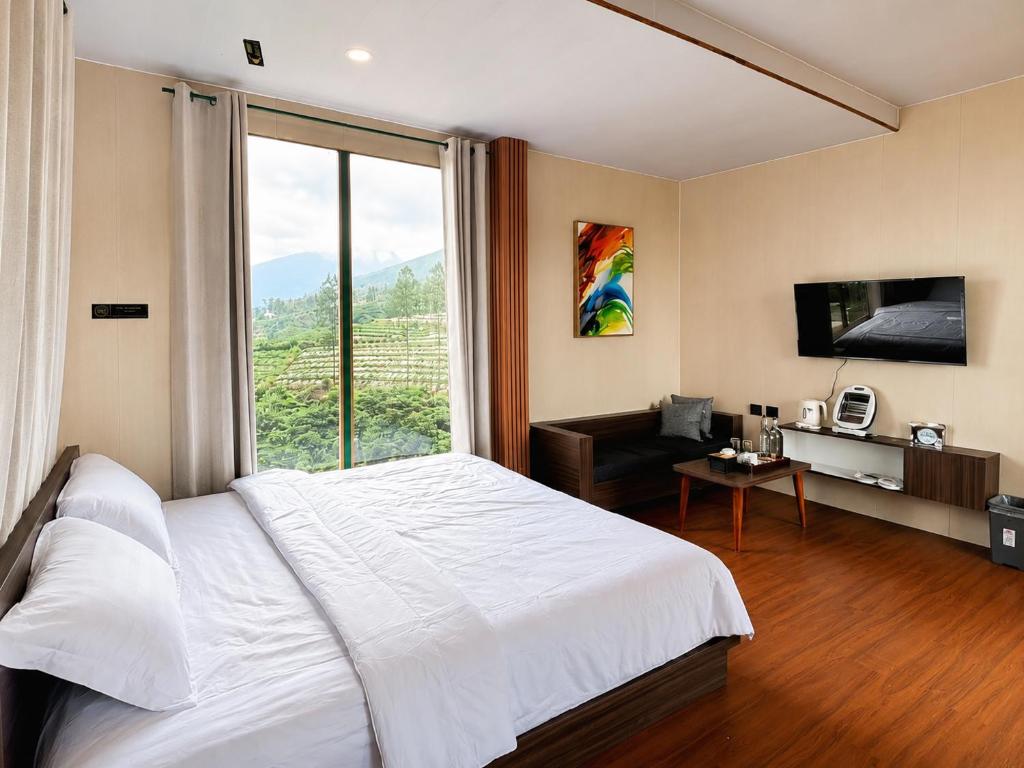 a bedroom with a white bed and a large window at 1440 MDPL Villa & Resort in Wonosobo