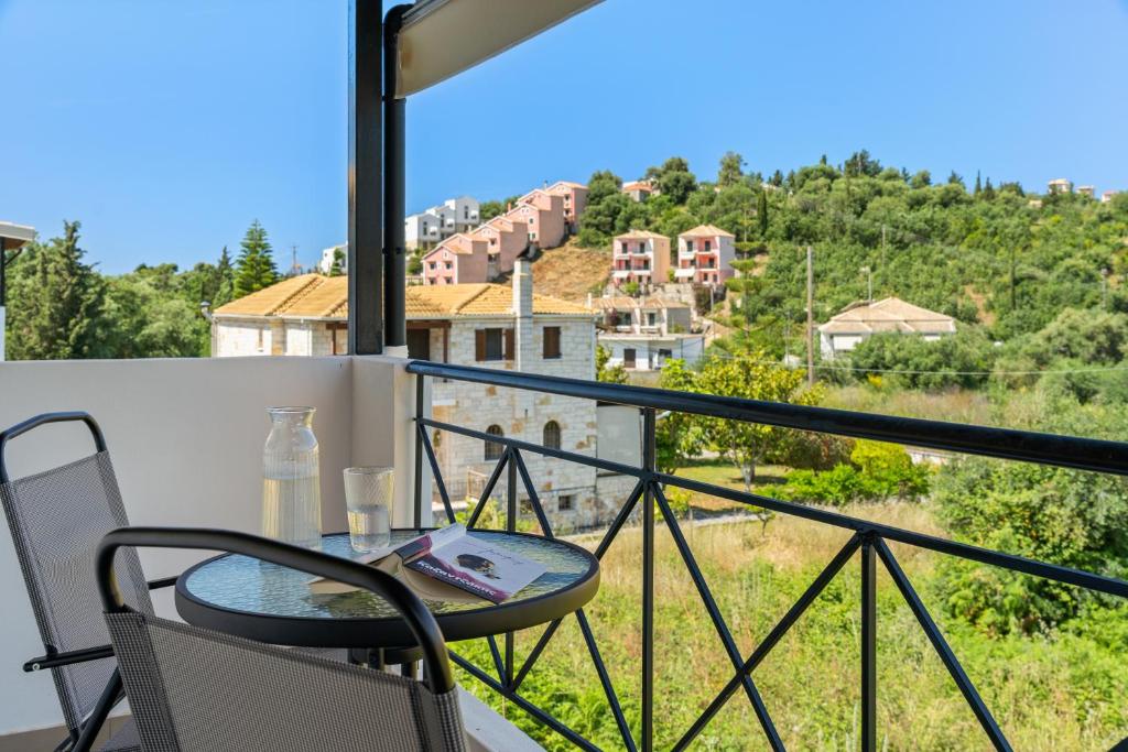 a balcony with a table and chairs and a view at The Dandy Family Apartments in Syvota