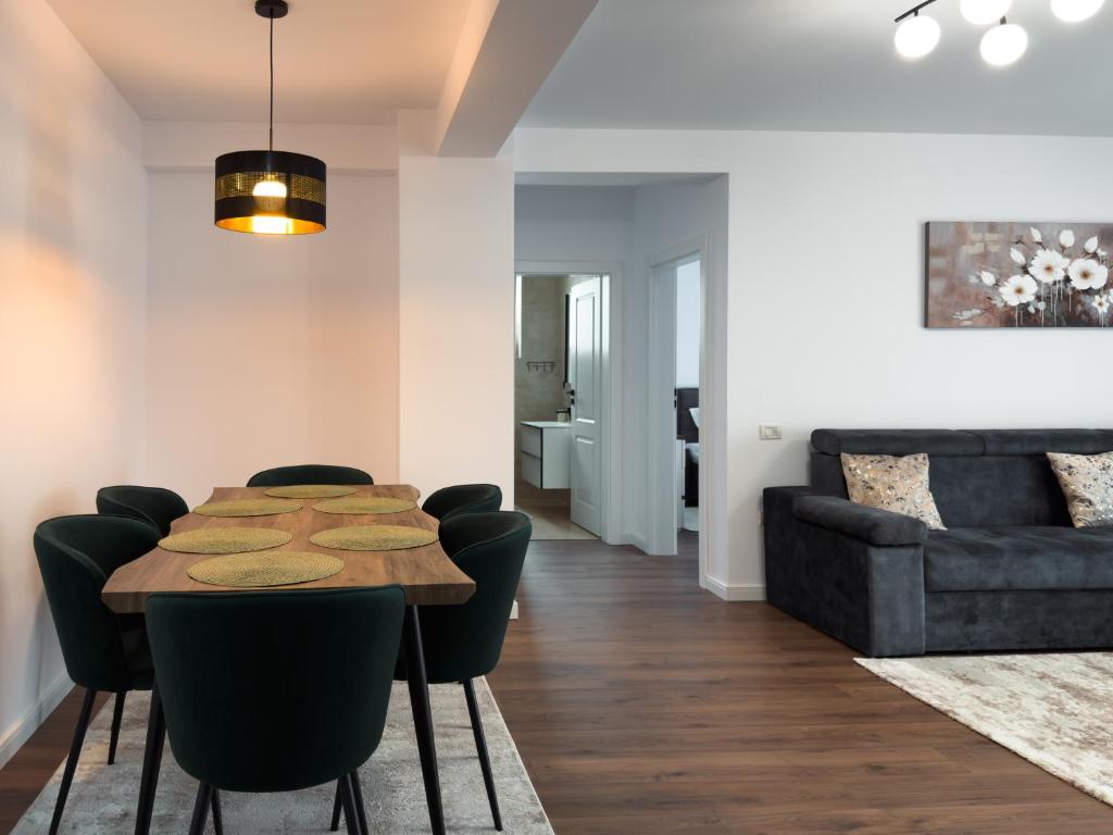 a dining room with a table and chairs and a couch at Bucovina Comfort Apartament in Gura Humorului