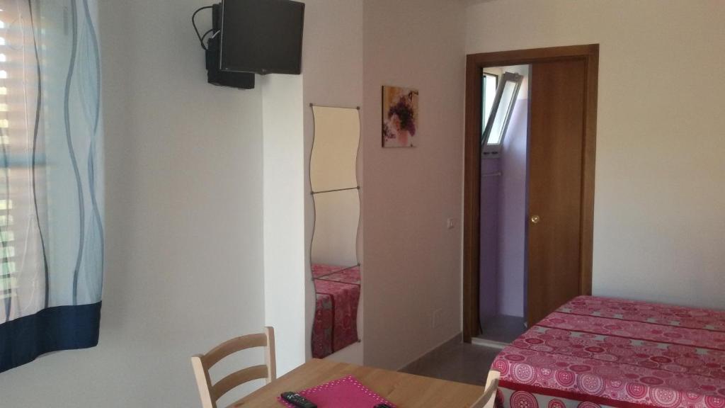 a small room with a table and a bed and a door at Green Garden Eco-Holiday in Vieste