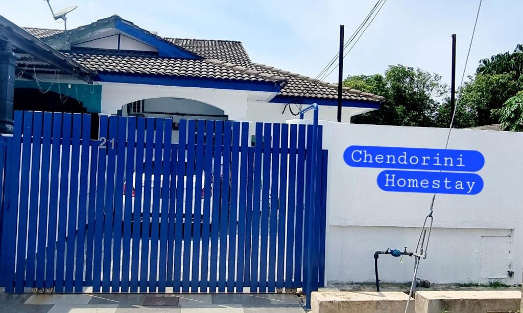 a blue gate in front of a white house at homestay chendorini cherating in Kampong Chendar