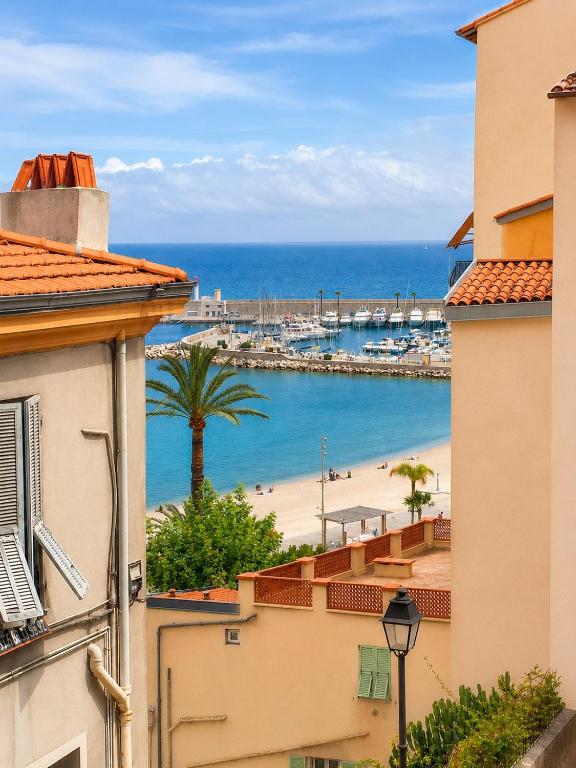 a view of a beach from between two buildings at Maison Julien 3 in Menton