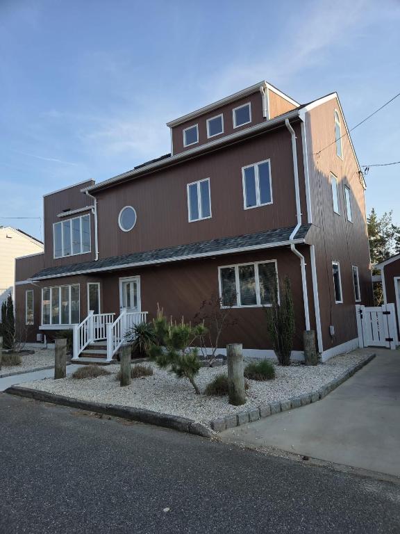 a large brown house with a white fence at Seascape in Haven Beach