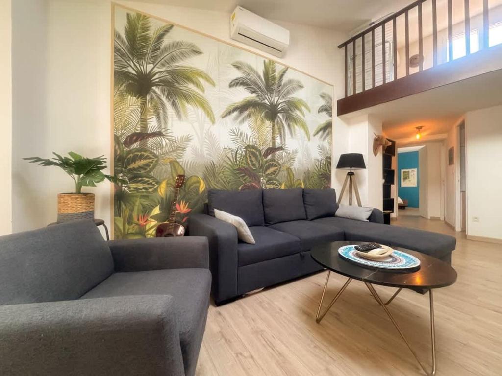 a living room with a blue couch and a table at The globe trotter - Perpignan in Perpignan