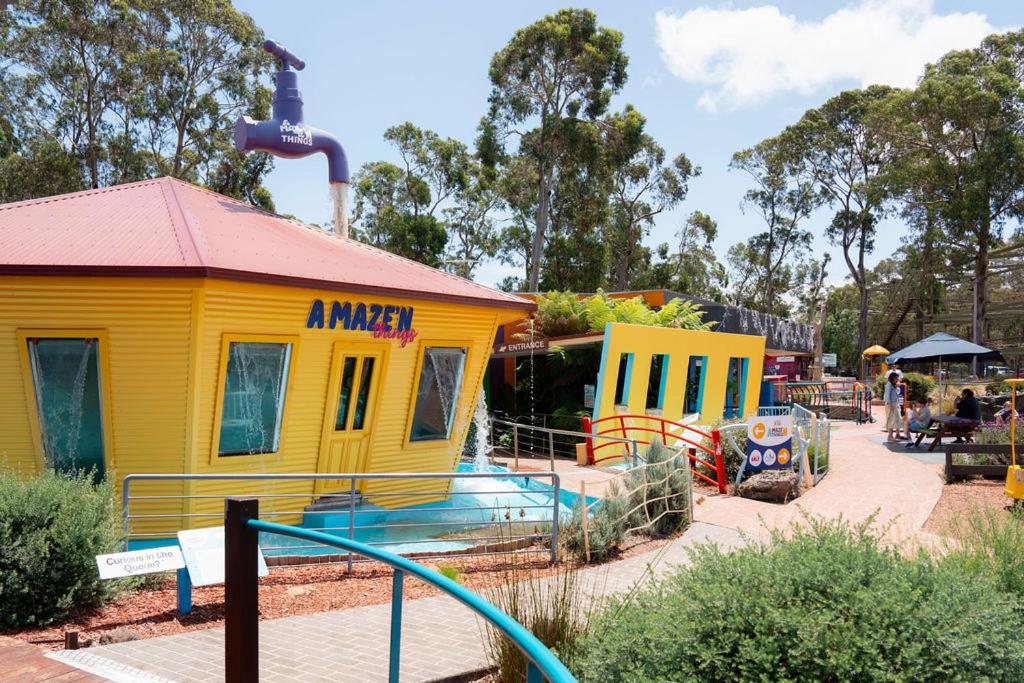 a small yellow building next to a playground at Phillip Island Park Lane Holiday Park in Cowes