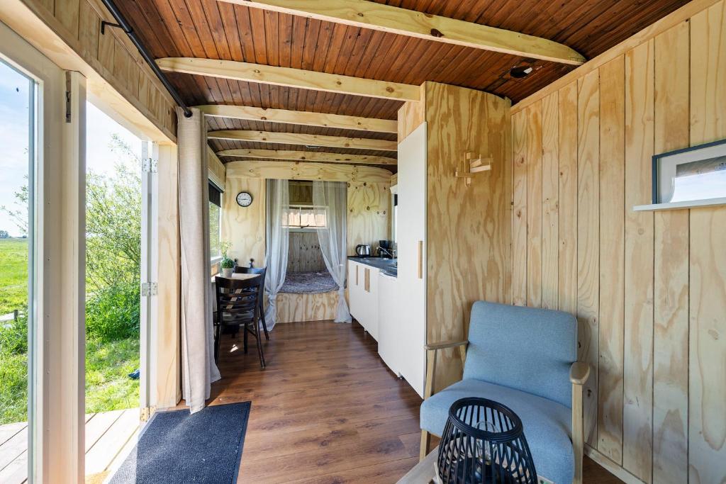 an interior view of a tiny house with wood paneling at Camping de Wartenster - De Pipowagen in Wartena