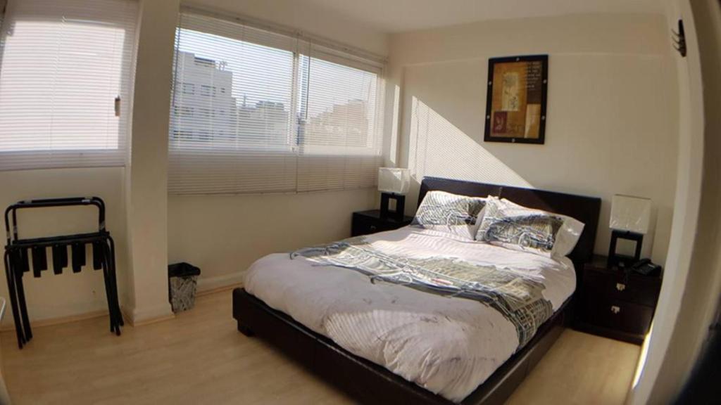 ein Schlafzimmer mit einem Bett und einem großen Fenster in der Unterkunft WTC Loft Nápoles El Cuarto Cielo in Mexiko-Stadt