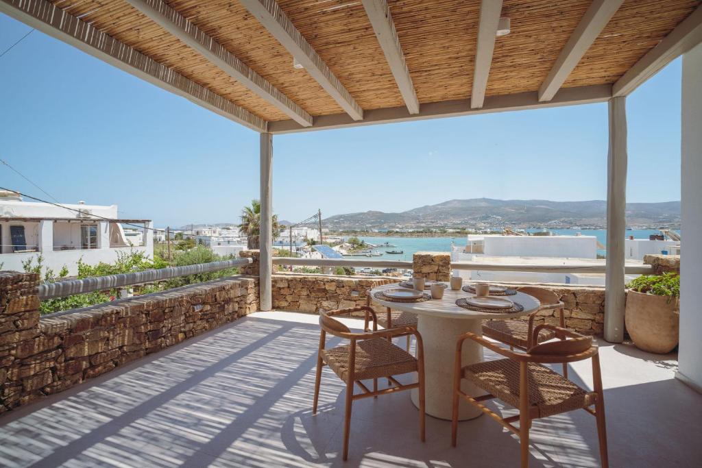 a patio with a table and chairs and a view of the ocean at 5 Elements - Agapi's Houses in Antiparos