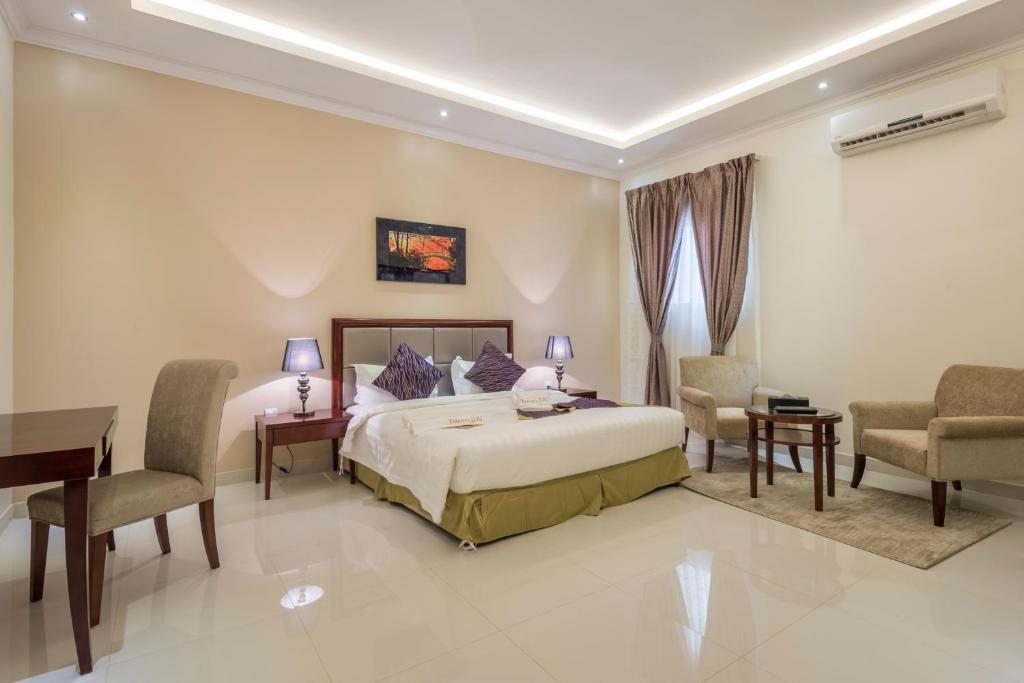 a bedroom with a bed and a desk and chairs at Taleen Al Anfal ِAl Naseem Al Sharqy in Riyadh