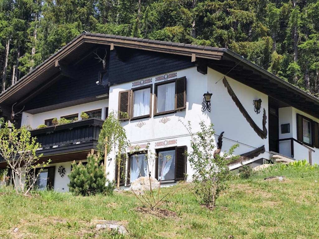 a white house with a black roof at Chalet Glauninger in Ramsau am Dachstein