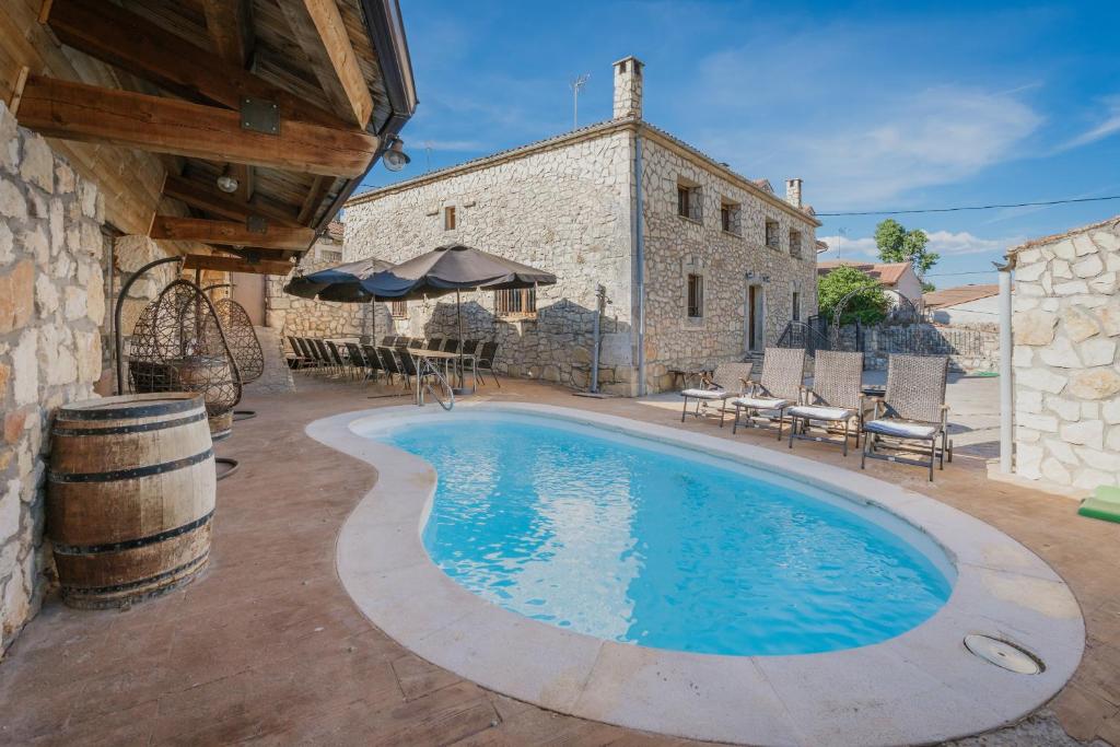 a swimming pool in front of a building at Sanz in Castro de Fuentidueña