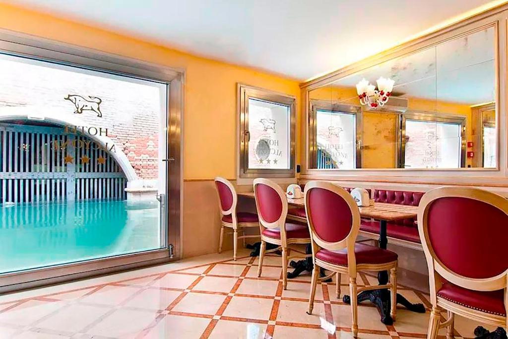 a restaurant with a table and chairs and a swimming pool at Hotel Alcyone in Venice