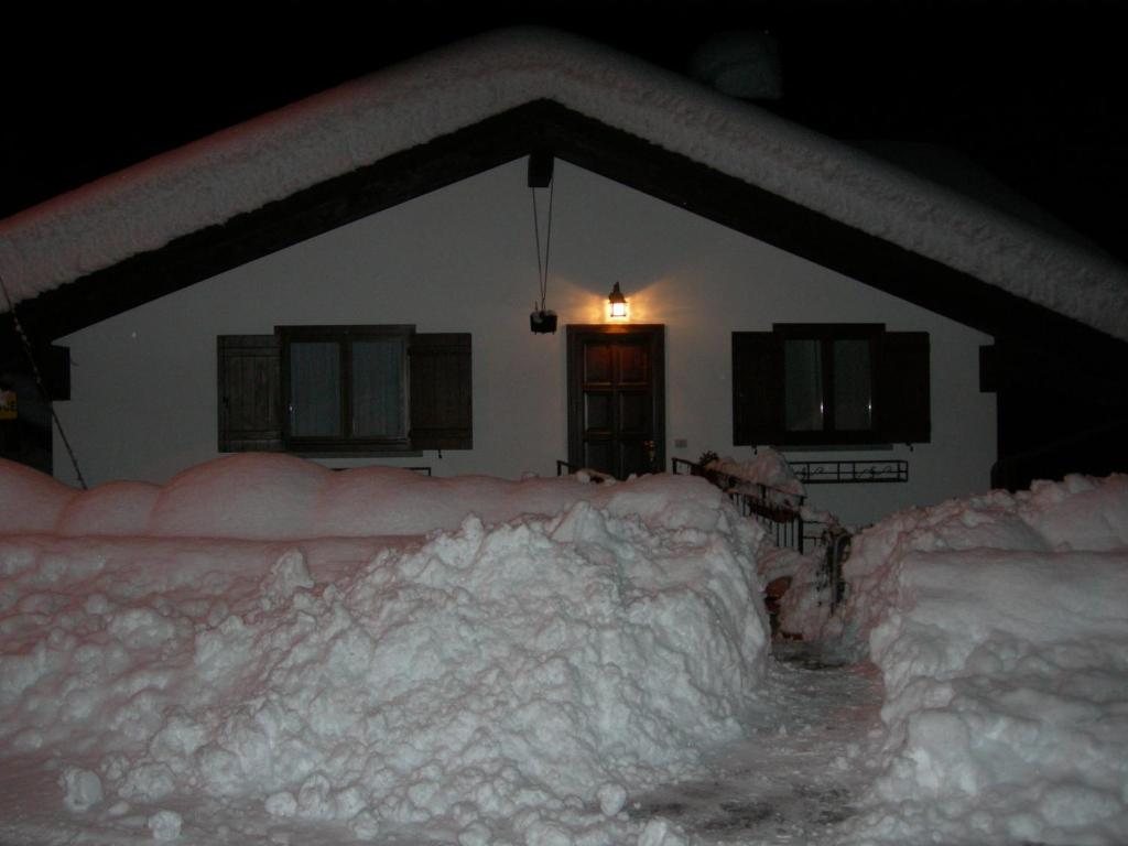 dom jest pokryty śniegiem w nocy w obiekcie La posa sul lago w mieście Rimasco