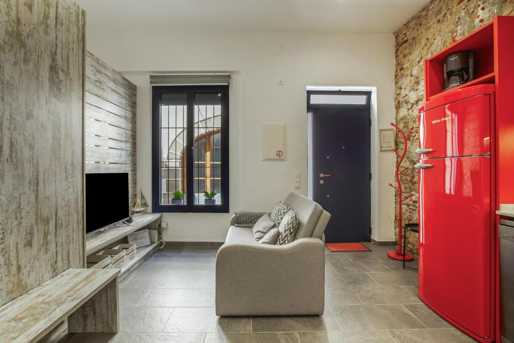 a living room with a couch and a red refrigerator at Petit Loft in Canet de Mar