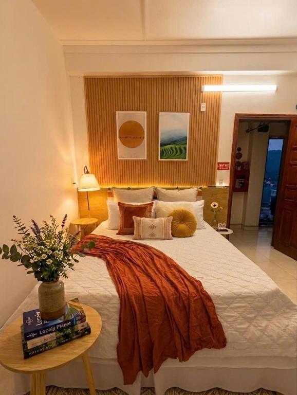 a bedroom with a large bed and a table at The Ha Giang Loop Hostel in Ha Giang