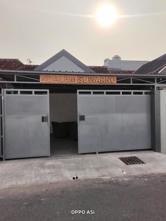 a building with two garage doors and a sign on it at Dalem Suwarno Baru in Timuran