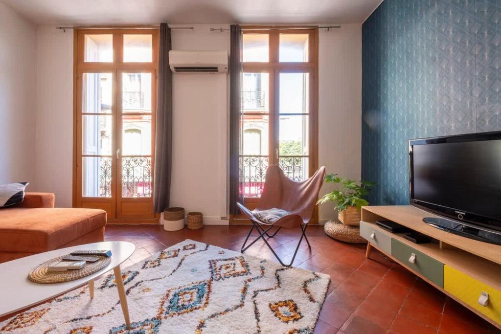 a living room with a couch and a tv at Le Balcon Catalan - Perpignan Centre in Perpignan