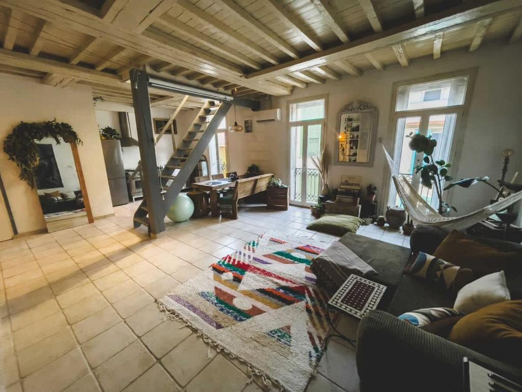 a living room with a couch and a staircase at O Saudade - Centre Perpignan in Perpignan