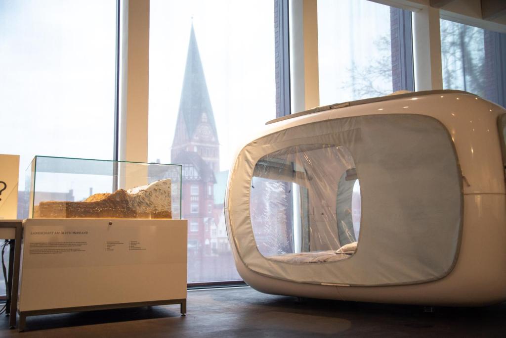 an old television sitting in a room with a window at One Night in a Museum - LUNA Sleep Cube in Lüneburg