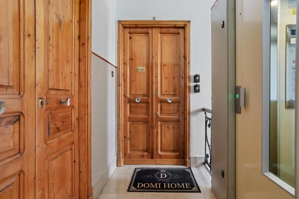 a hallway with a wooden door and a do not disturb rug at Domi Home in La Spezia