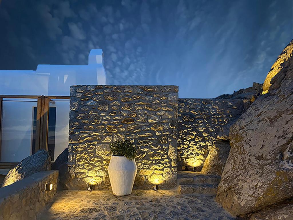 a white vase sitting on a stone wall with lights at CHARMA Mykonos in Kalo Livadi