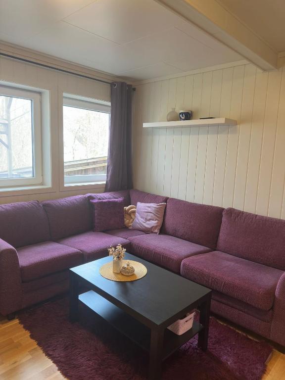 a living room with a purple couch and a coffee table at Cozy 2-Bedroom Apartment in Kristiansand