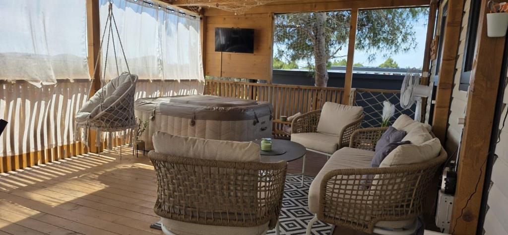 a screened in porch with chairs and a table at Mobile home Bokun sriće in Drage