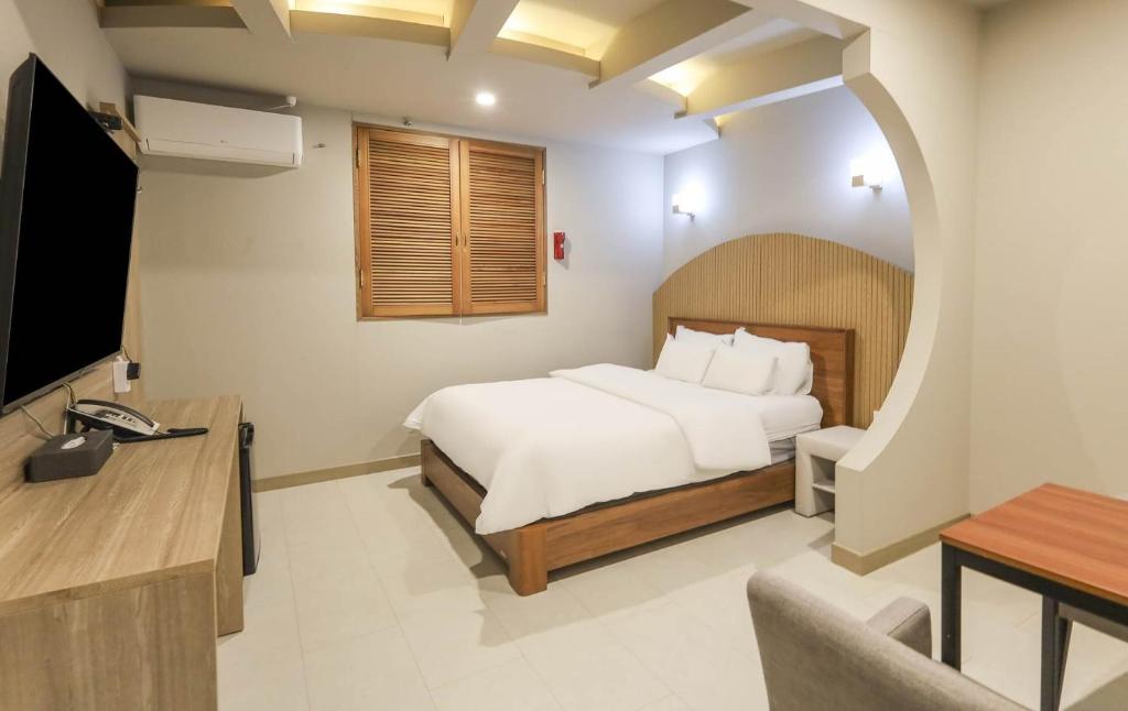 a hotel room with a bed and a television at 계룡 호텔 스테이318 in Gyeryong