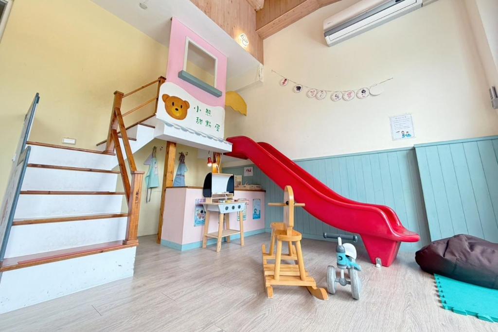 a kids room with a slide and a bunk bed at Village Villa B&B in Zhuqi