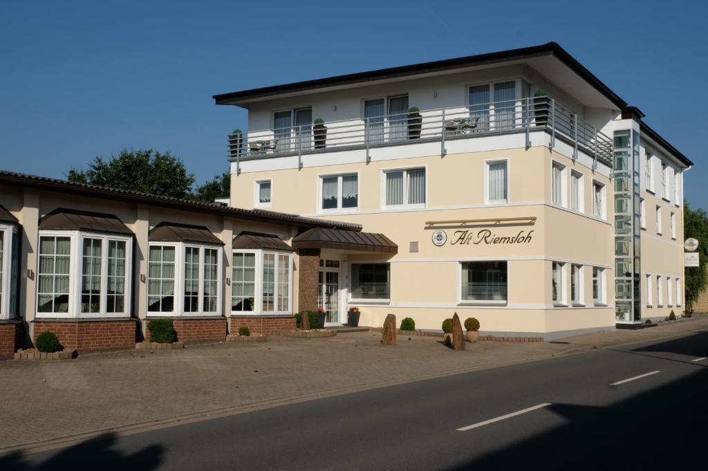 a large white building on the side of a street at Hotel Alt Riemsloh in Melle