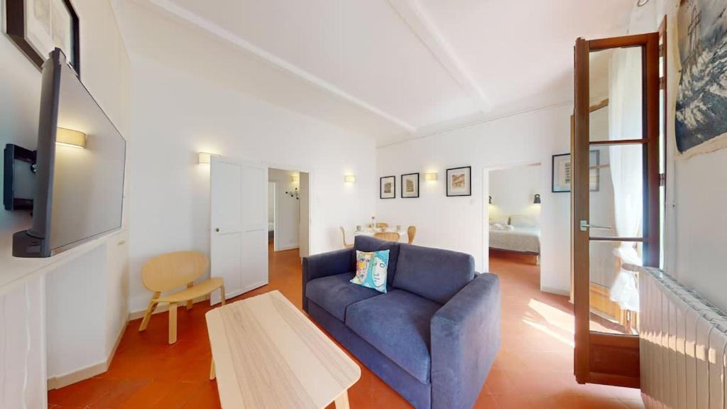a living room with a blue couch and a table at L'atelier de la rue Mailly in Perpignan