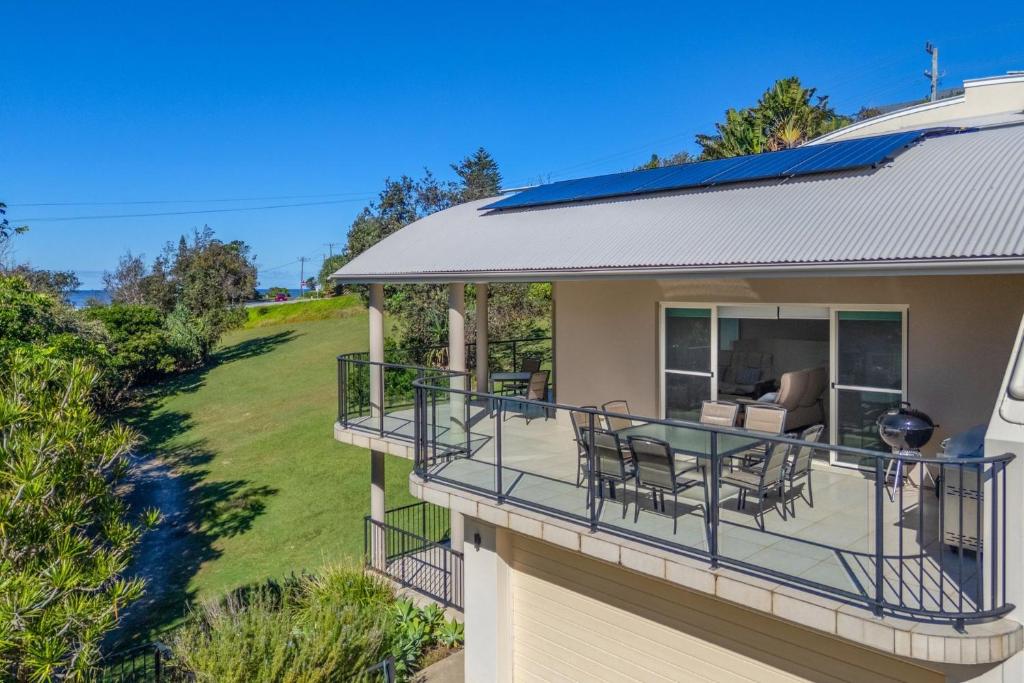 a house with a balcony with a table and chairs at Surfside in East Ballina