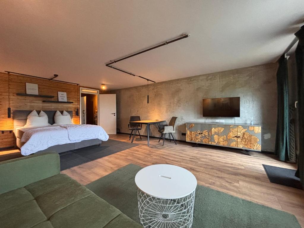 a bedroom with a bed and a tv on a wall at Terrassenpark Apartments in Sasbachwalden