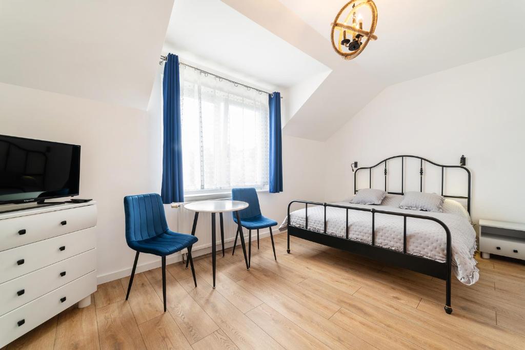 a bedroom with a bed and a table and chairs at Willa Promyk in Jastarnia