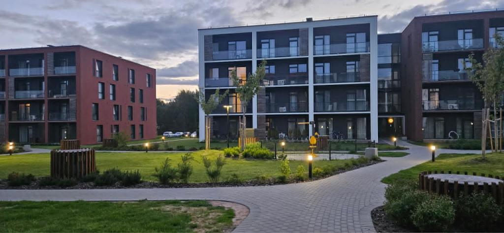 an exterior view of two apartment buildings at dusk at Karaliauciaus Apartment in Vilnius