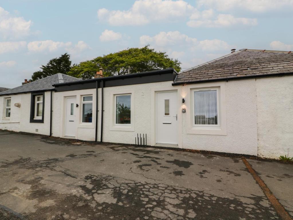 a row of houses with white doors in a parking lot at Rosalin Cottage in Irvine