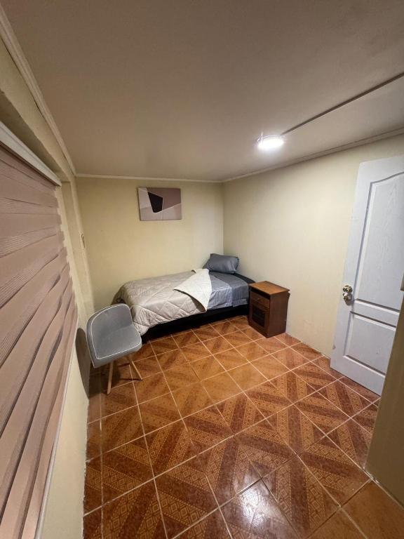 a small bedroom with a bed and a door at Hostel Campus Lircay in Talca