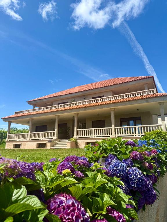 a large house with flowers in front of it at CASA DE AREAS in Sanxenxo