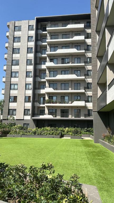 a large apartment building with a lawn in front of it at Luxury Aestethics at Bantree in Accra