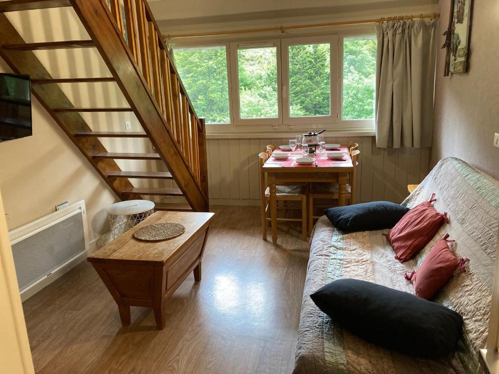 a living room with a couch and a table at Appartement residence bec aigle in Le Lioran