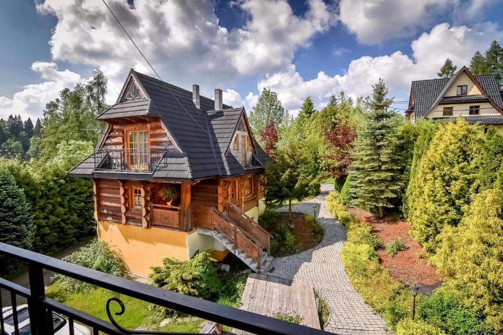 a wooden house with a black roof and a pathway at Willa Anna Bukowina Jacuzzi & Sauna in Bukowina Tatrzańska