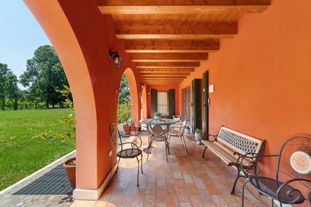 an outdoor patio with a table and chairs and a bench at Agriturismo Amoler in Mirano