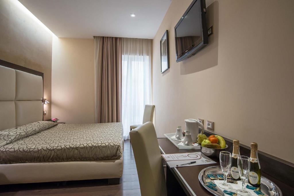 a hotel room with a bed and a table with a dining room at Catone District Hotel in Rome