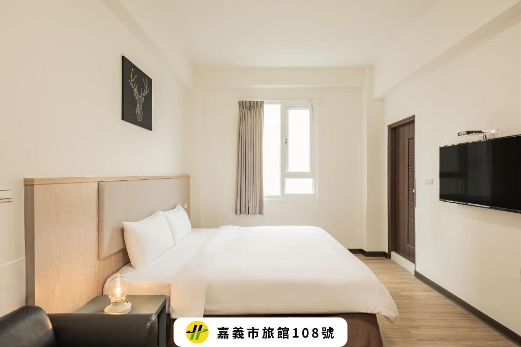 a hotel room with a bed and a television at Meant To Be in Chiayi City
