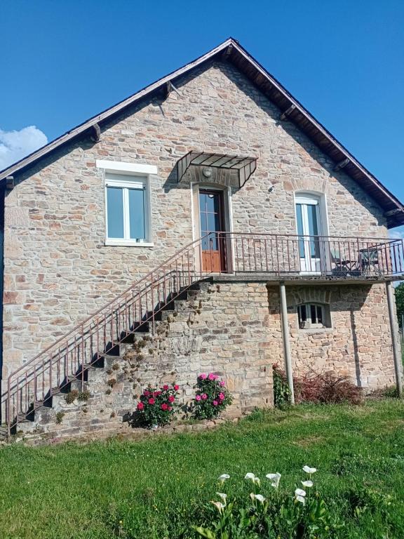 a brick house with a staircase on the side of it at Appartement en Corrèze in Le Lonzac